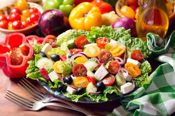 plate of greek salad on wooden table